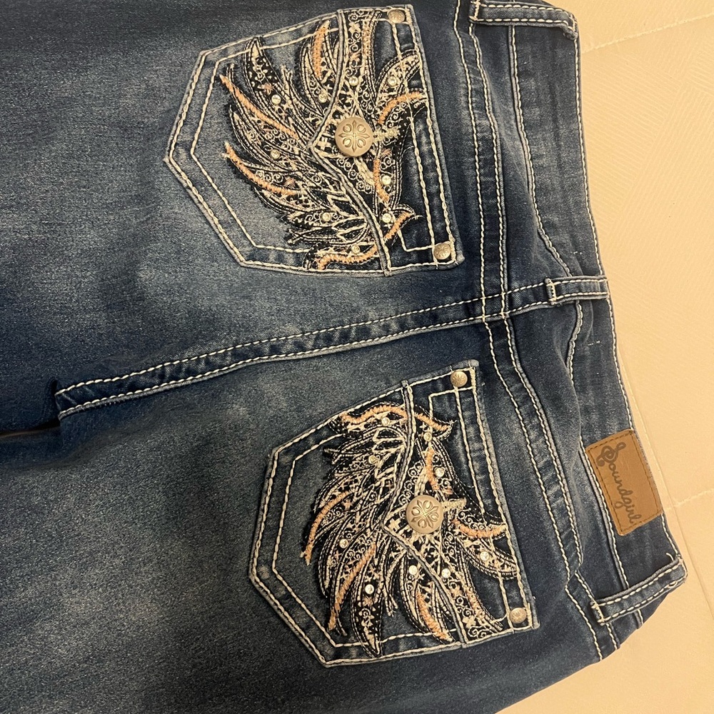 Medium wash jeans with pink button wing stitching